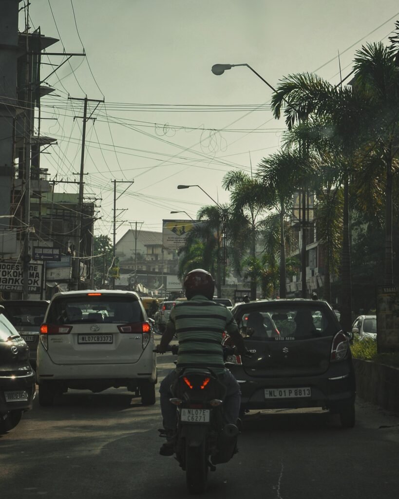 A busy Dimapur street with vehicles and roadside buildings